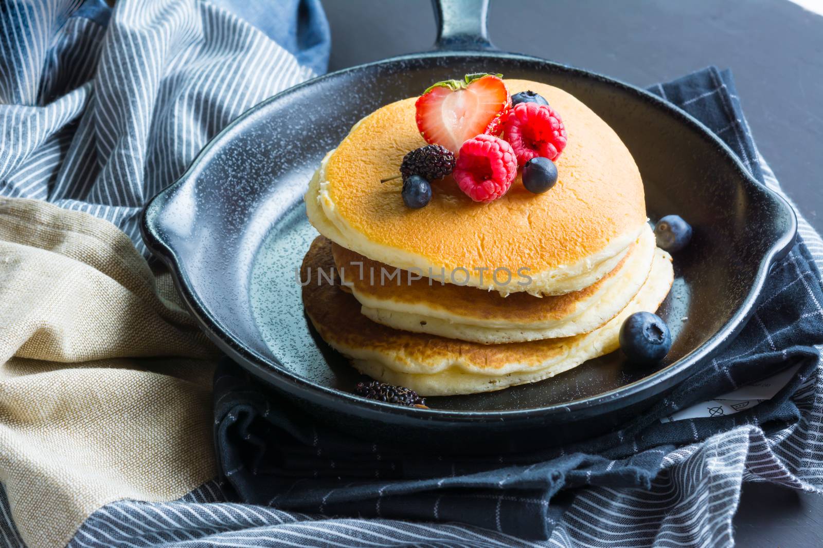 Pancakes with blueberries  & raspberry on wood background  by ahimaone