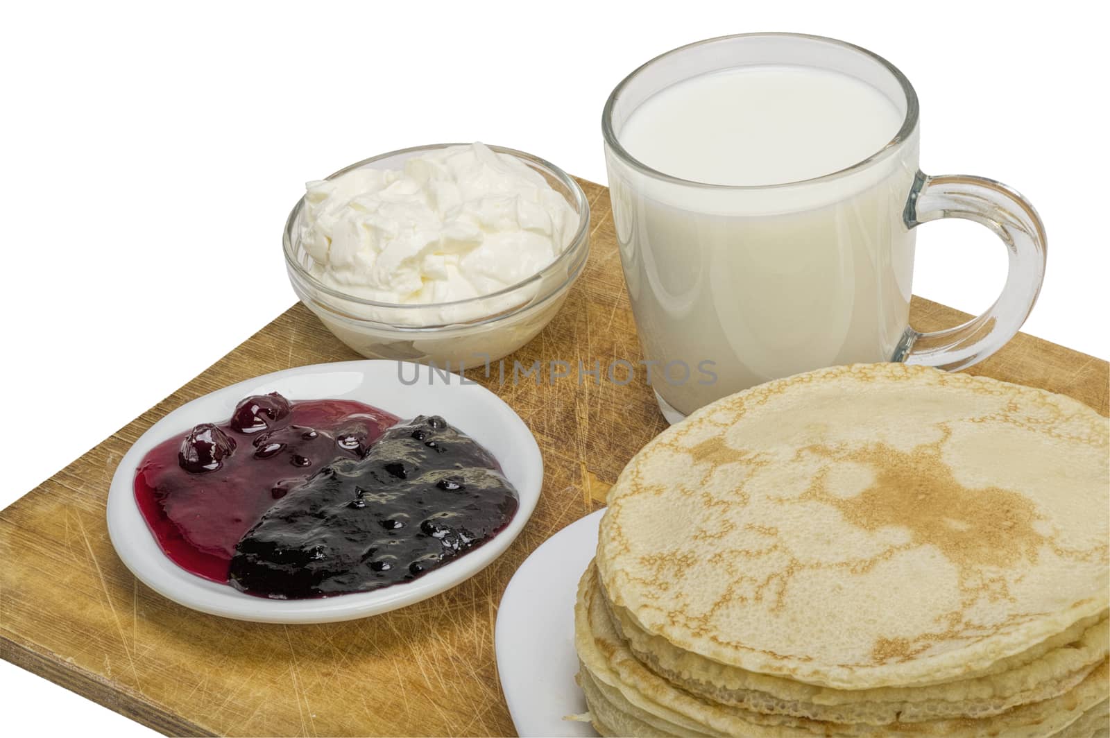 pancakes with jam and milk smeranoy on a wooden plank