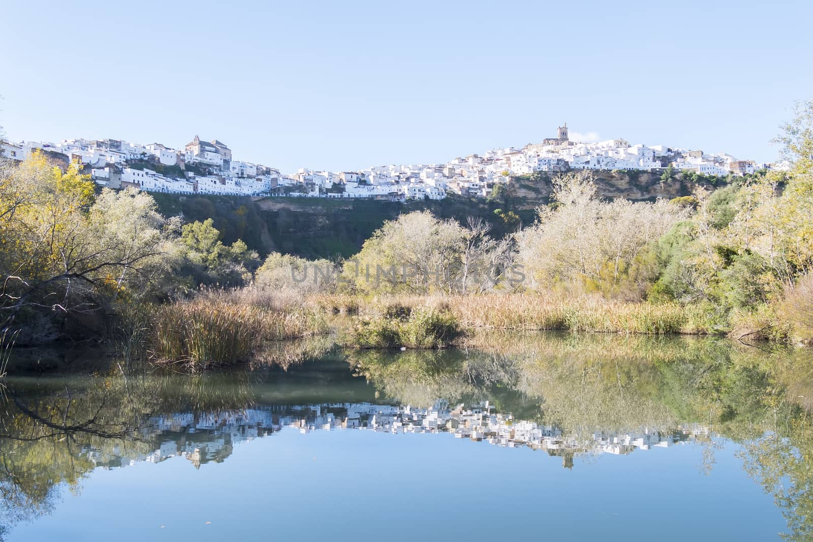 Panoramic of Arcos de la Frontera reflected in the river, white town built on a rock along Guadalete river, in the province of Cadiz, Spain