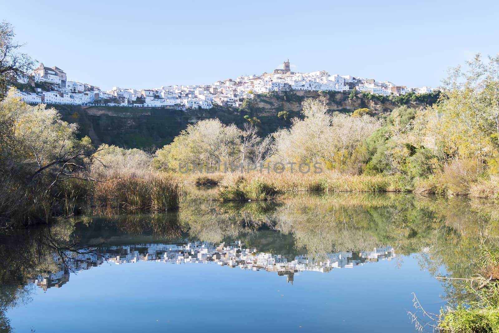 Panoramic of Arcos de la Frontera reflected in the river, white town built on a rock along Guadalete river, in the province of Cadiz, Spain