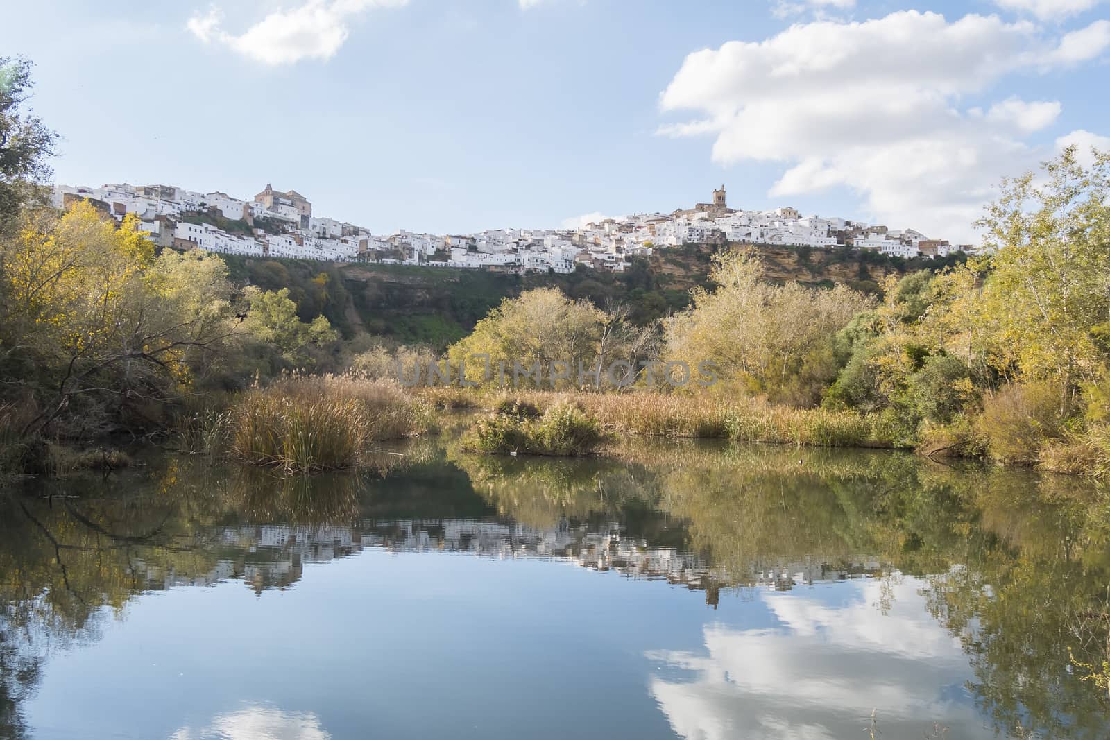 Panoramic of Arcos de la Frontera reflected in the river, white town built on a rock along Guadalete river, in the province of Cadiz, Spain