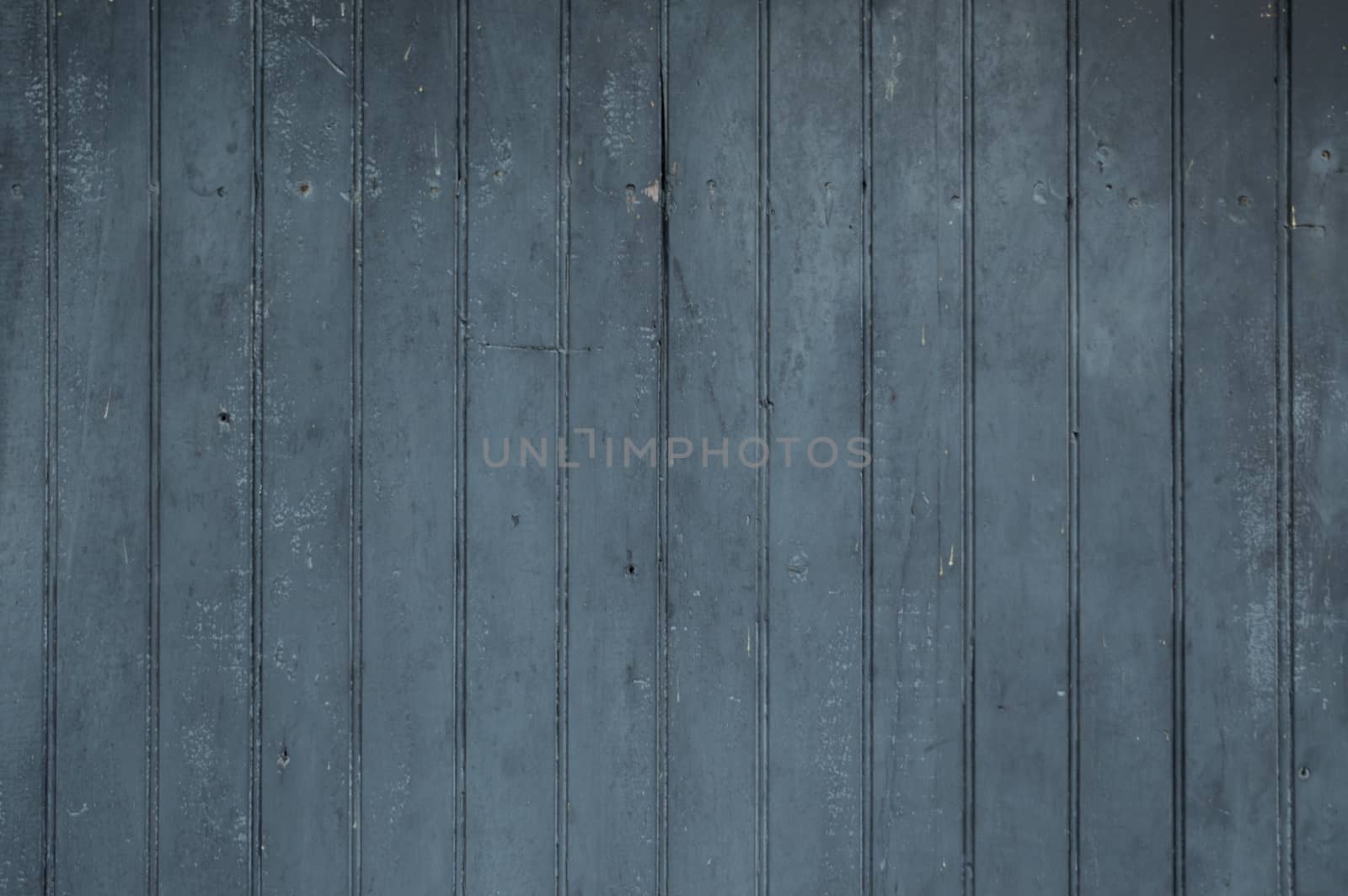 Black vertical faded worn weathered vertical wooden bead boards or wainscotting type planks.