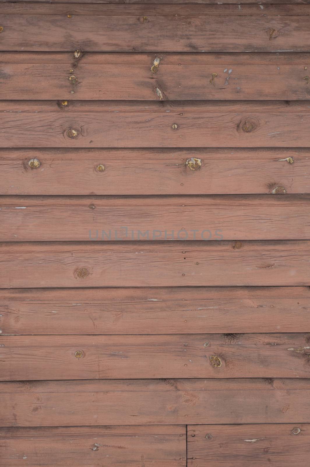 Horizontal running grungy brown stained painted planks and boards from a waterfront cottage.