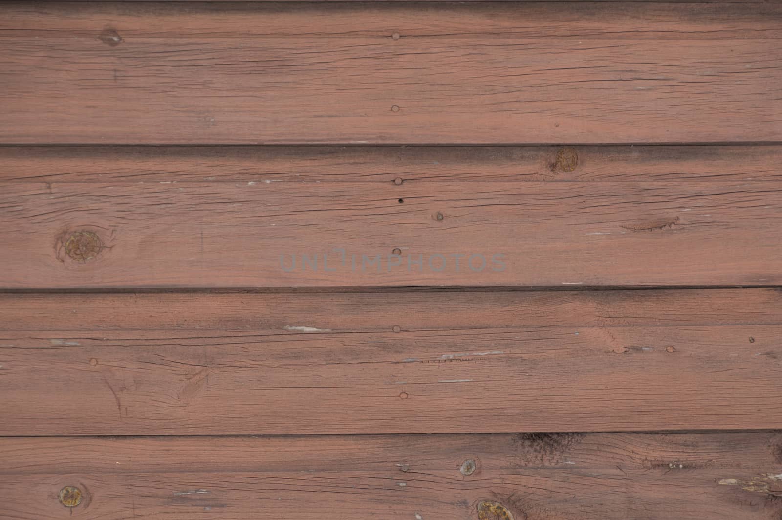 Horizontal running grungy brown stained painted planks and boards from a waterfront cottage.