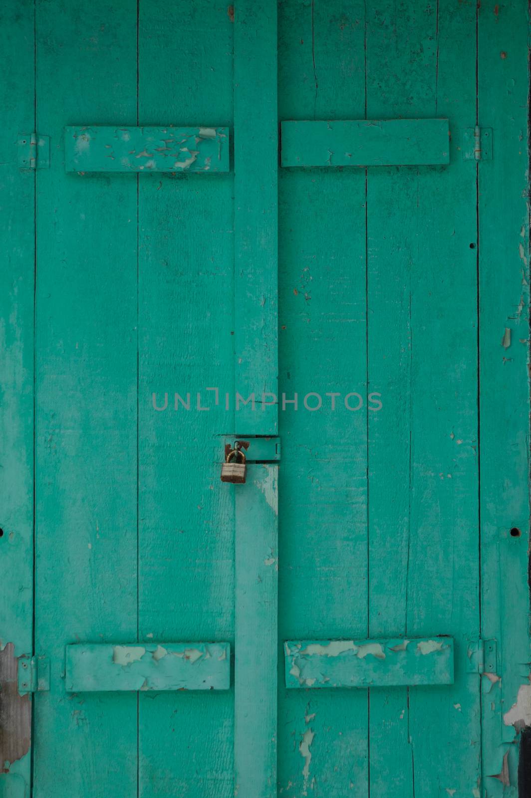 Grungy faded green mildewy shuuters on a waterfront cottage.  Locked on a black cottage in winter