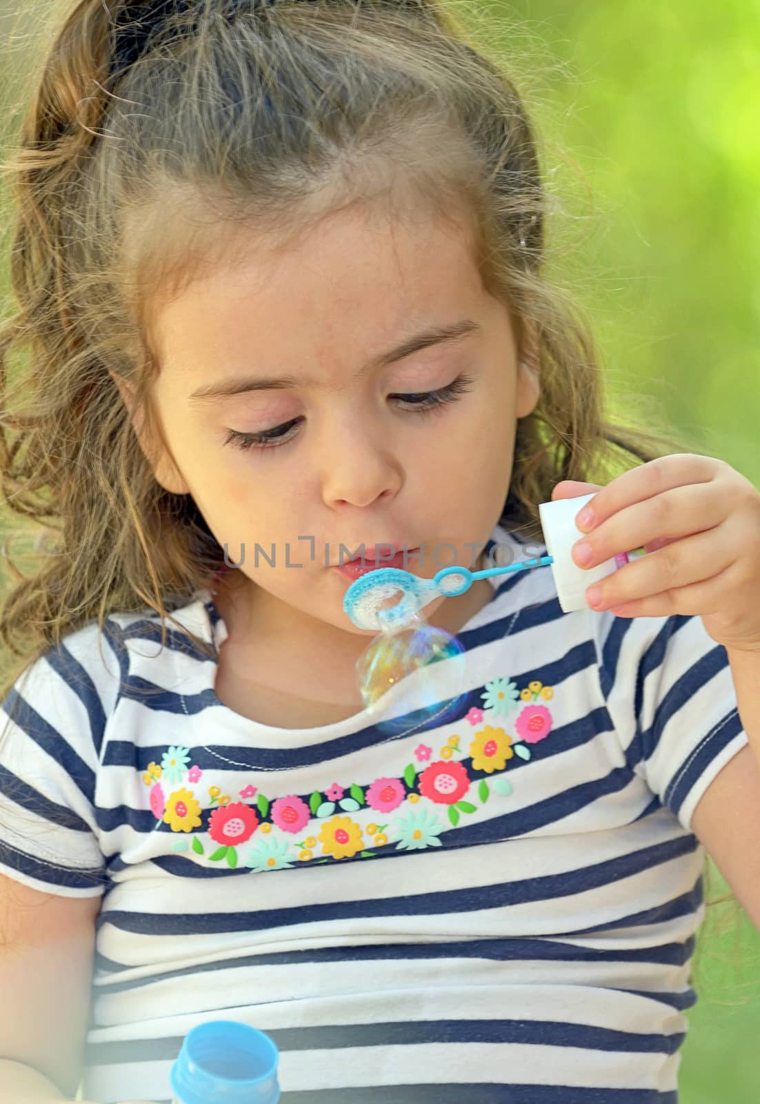 Child blowing soap bubbles by jordachelr