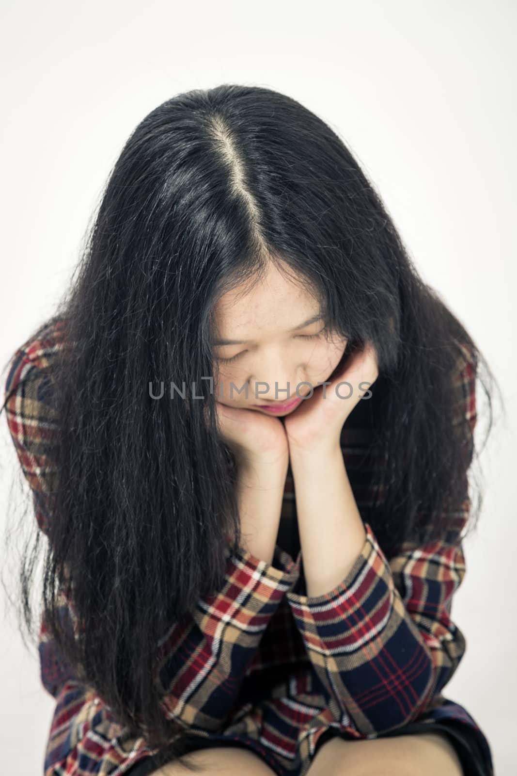 Chinese teenager sad with head in hands