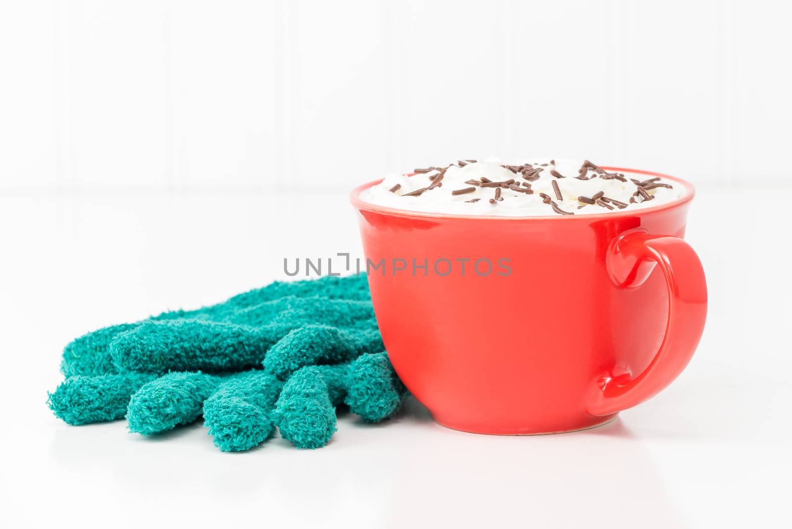 Mug of hot chocolate with whipped cream and chocolate sprinkles.