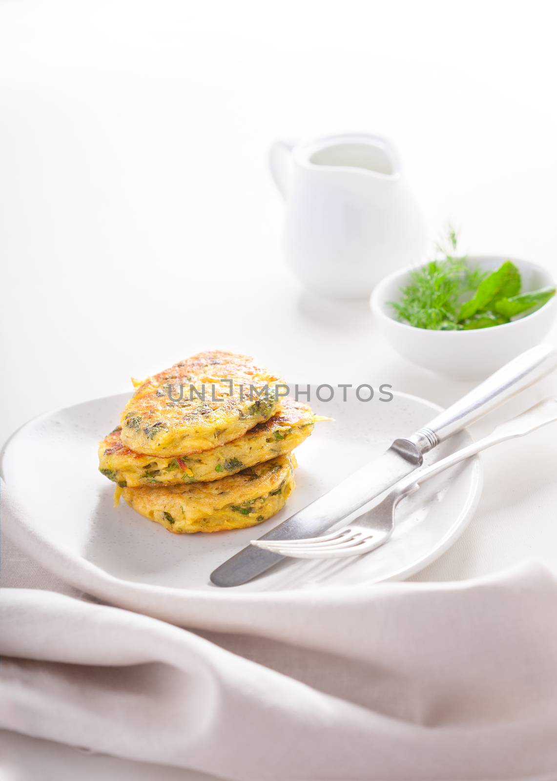 Healthy vegetarian zucchini fritters on a white surface