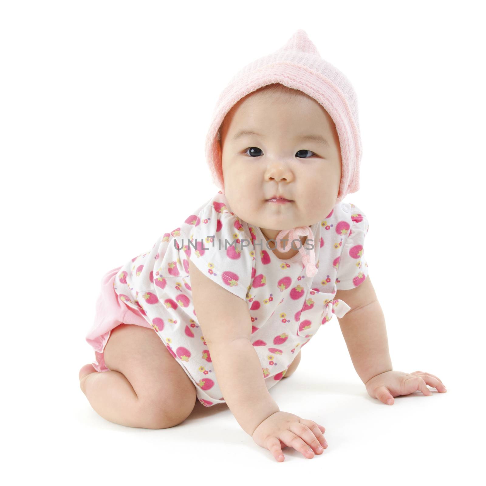 Portrait of full length cute Asian baby girl in pink clothes crawling on floor, isolated on white background.