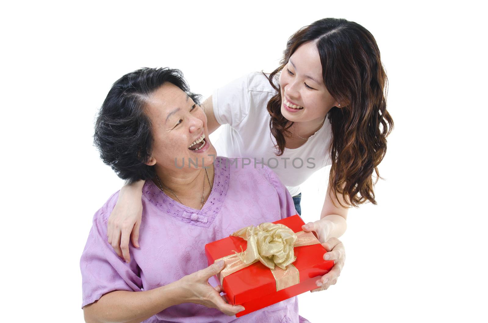 Celebrating mothers day or birthday. Portrait of Asian senior parent getting a present box from adult daughter, isolated on white background.