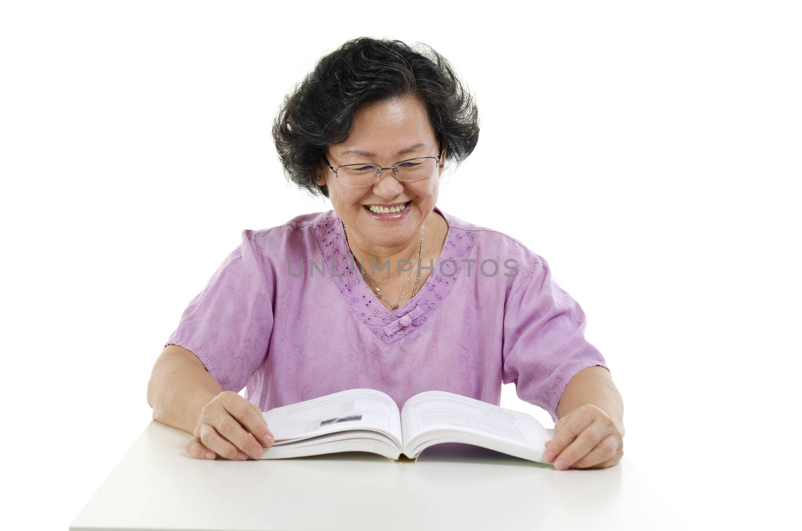 Portrait of wise Asian senior adult woman reading book, isolated on white background.