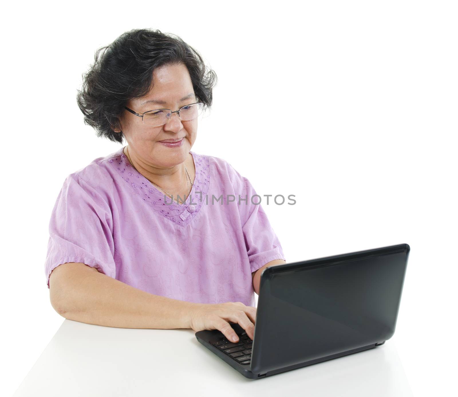 Senior adult woman using laptop computer by szefei