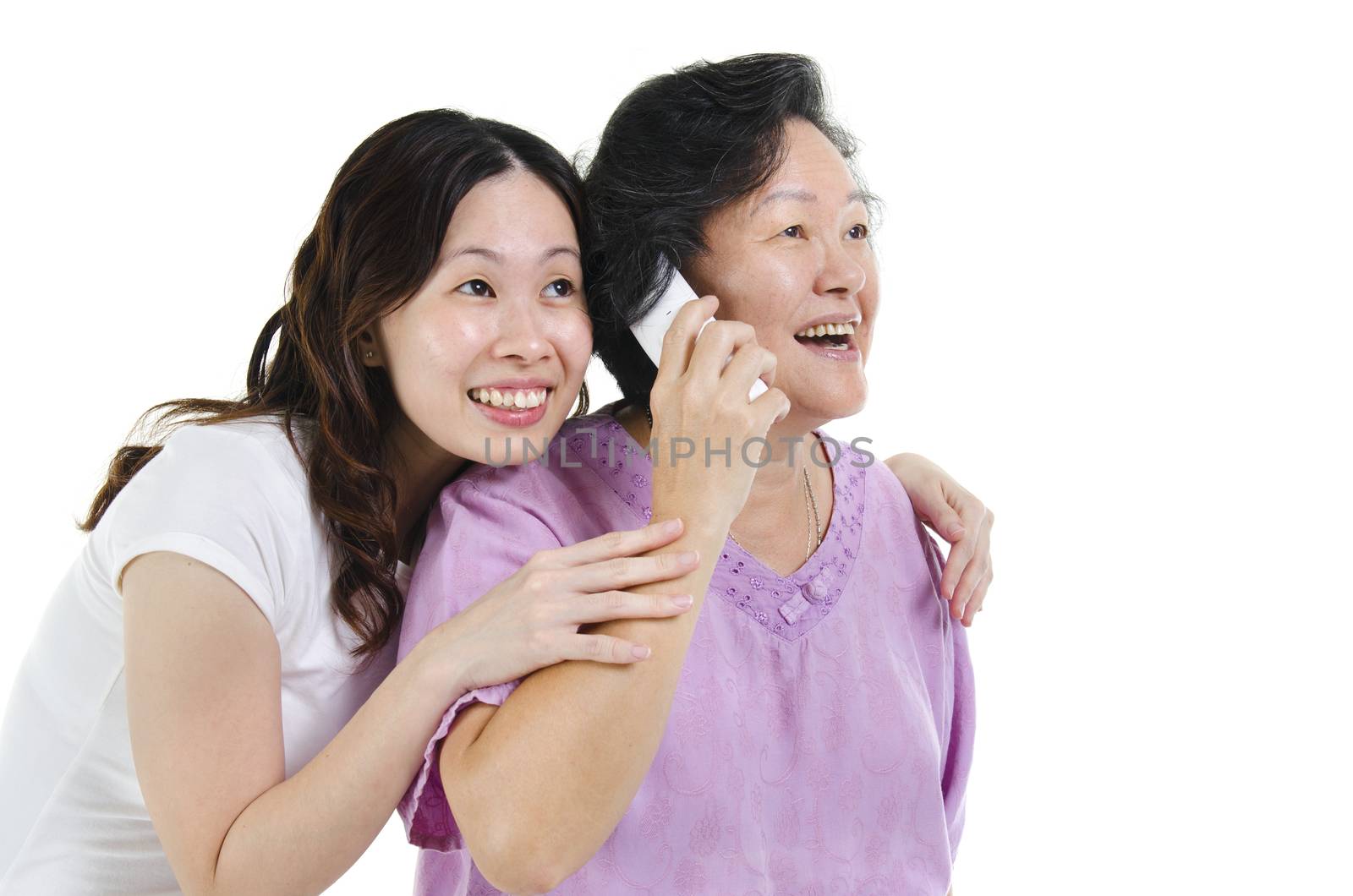 Portrait of Asian senior mother calling on phone, sharing with adult daughter and smiling, isolated on white background.