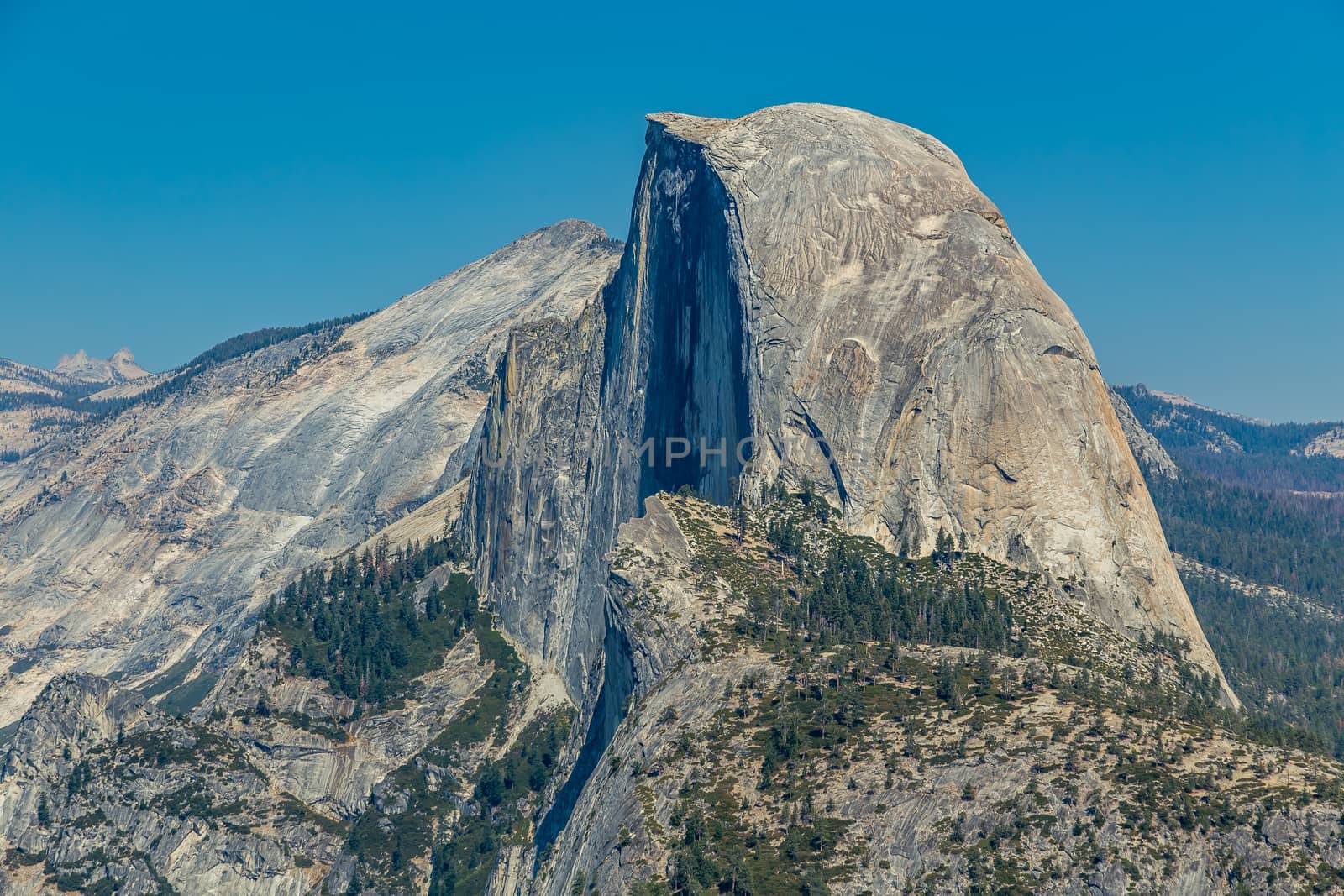 Half Dome is a granite dome at the eastern end of Yosemite Valley in Yosemite National Park, California. It is a well-known rock formation in the park, named for its distinct shape. One side is a sheer face while the other three sides are smooth and round, making it appear like a dome cut in half. The granite crest rises more than 4,737 ft above the valley floor.