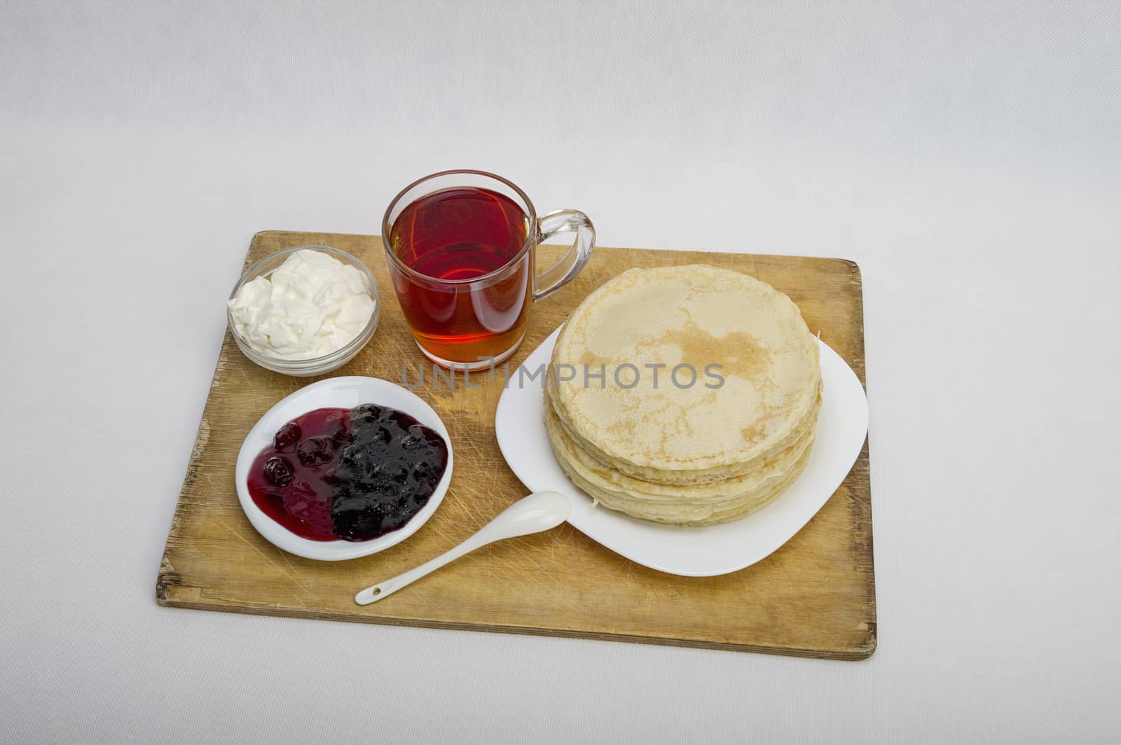 pancakes with jam and milk smeranoy on a wooden plank