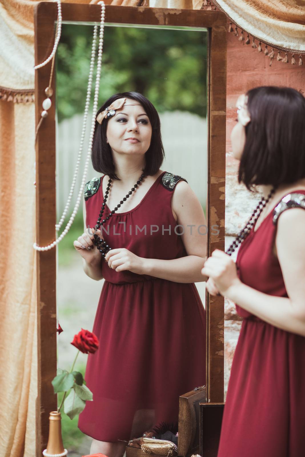 woman in retro style standing and looking in a mirror