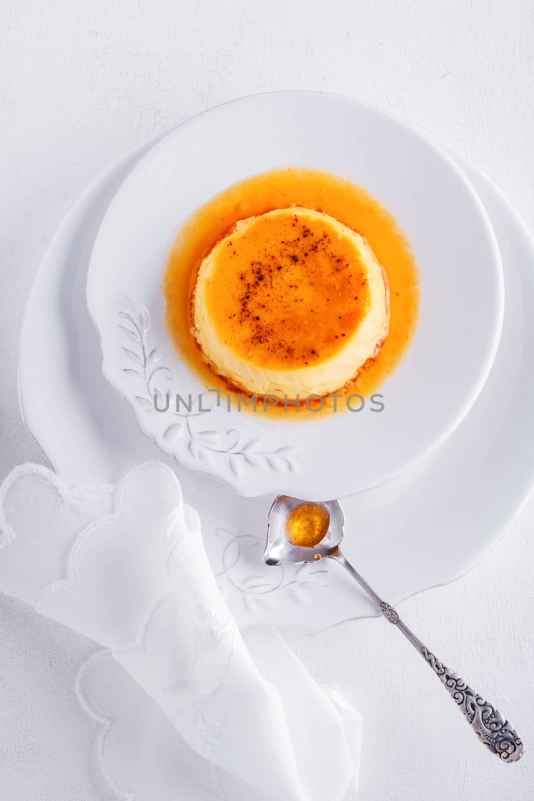 Creme Caramel on a plate served on a table.