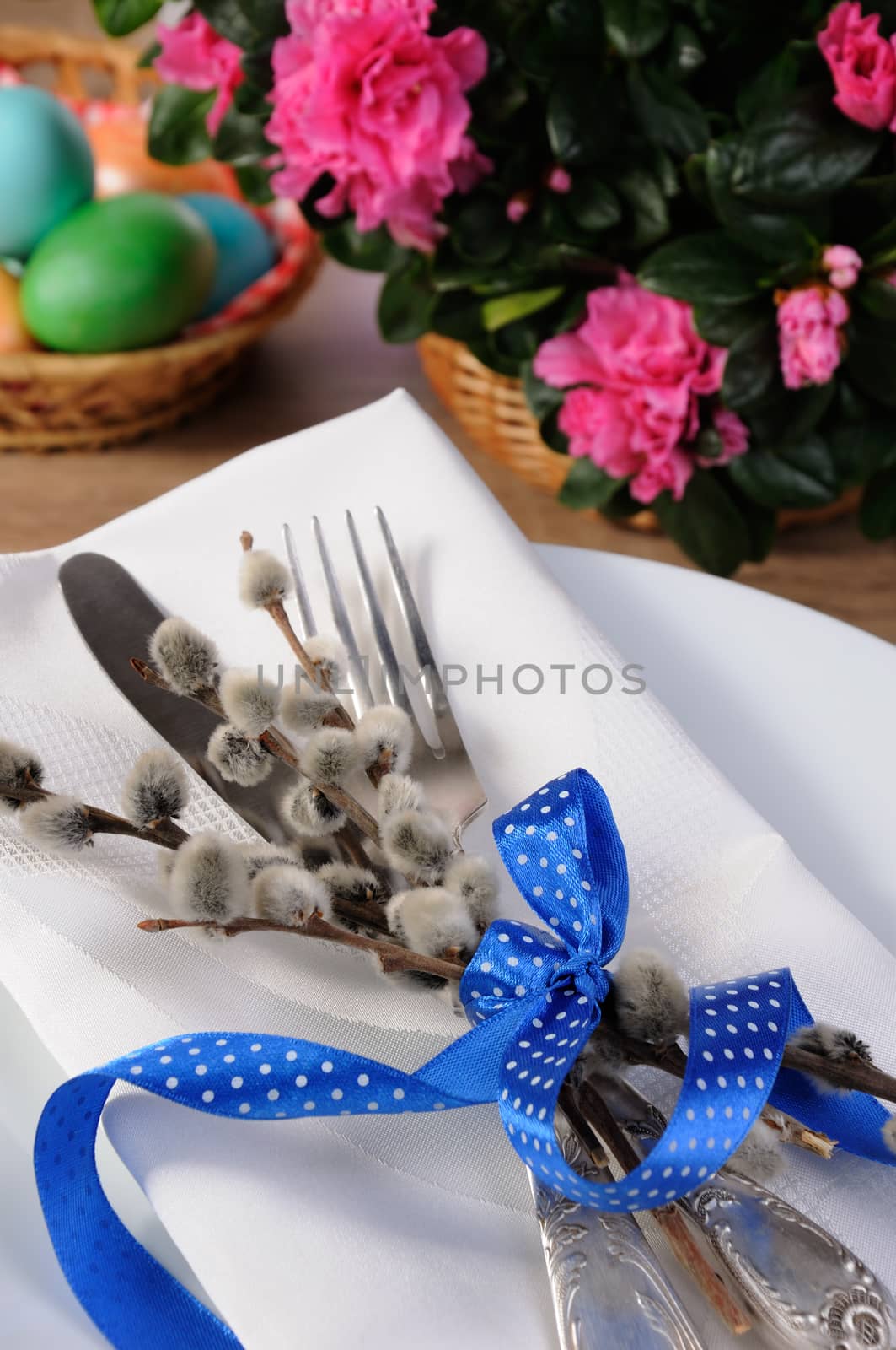 Decorations for Easter. Knife and fork with pussy-willow branches tied with ribbon on a napkin