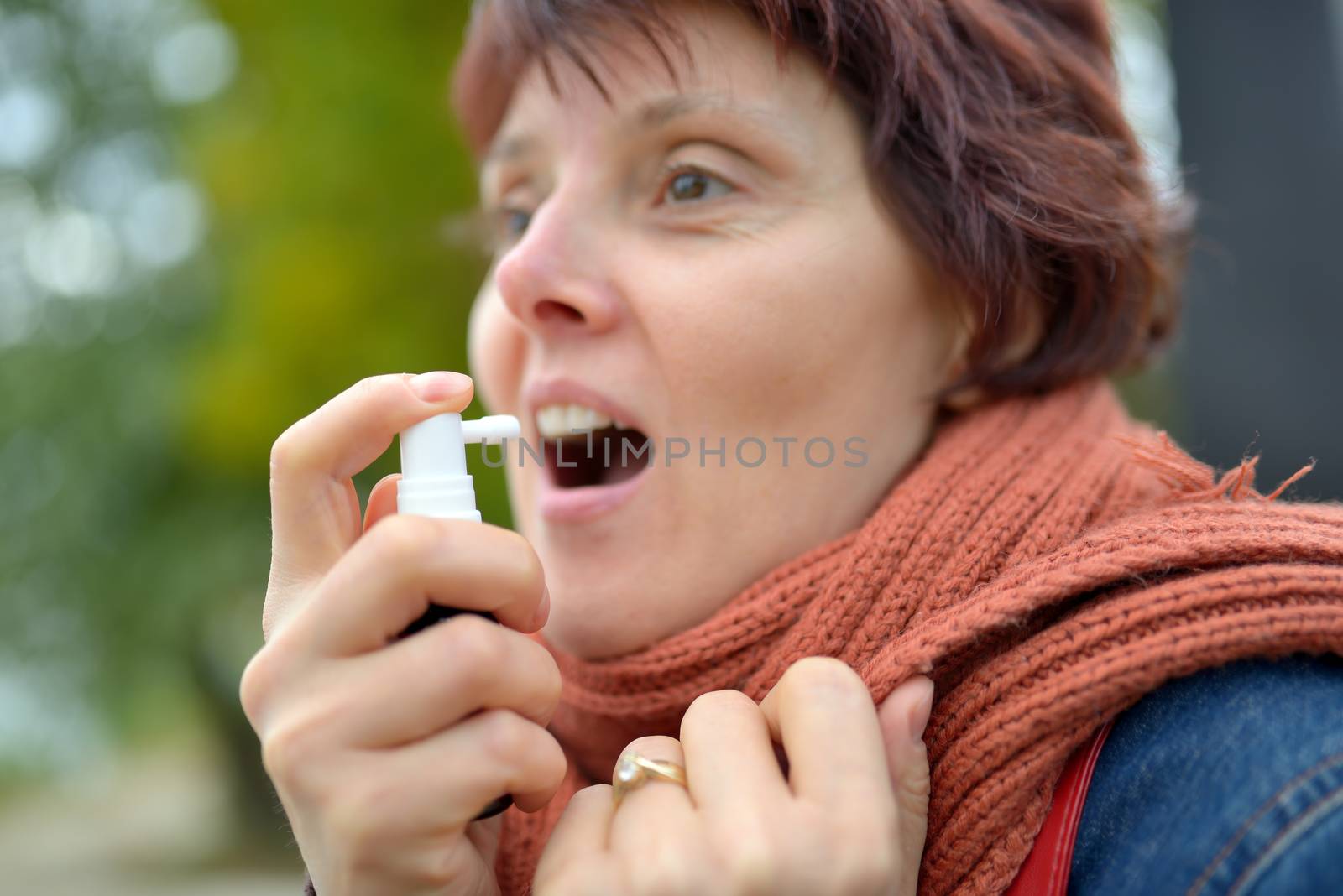 Young woman using throat spray by mady70