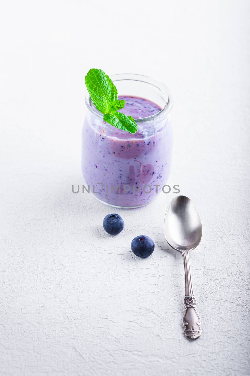 Delicious blueberry yoghurt smoothie with a spoon
