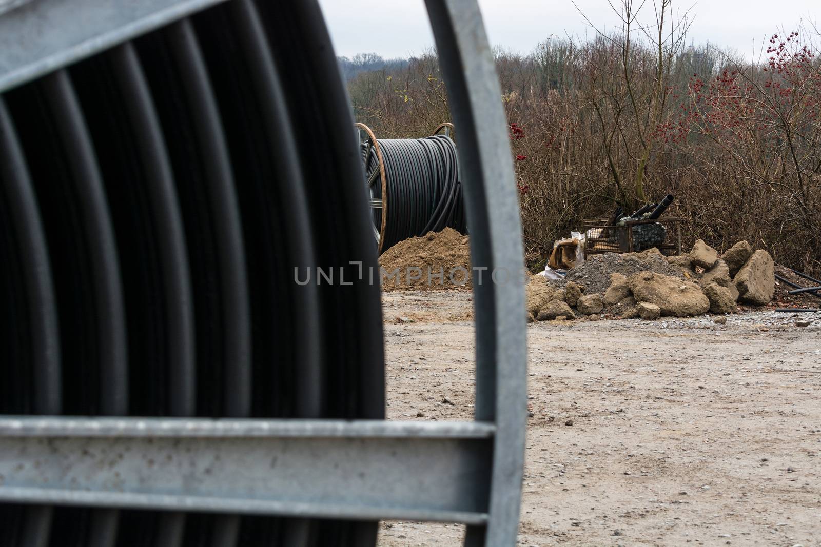 Steel roller with fiber optic cables for the installation of data cables on a construction site.