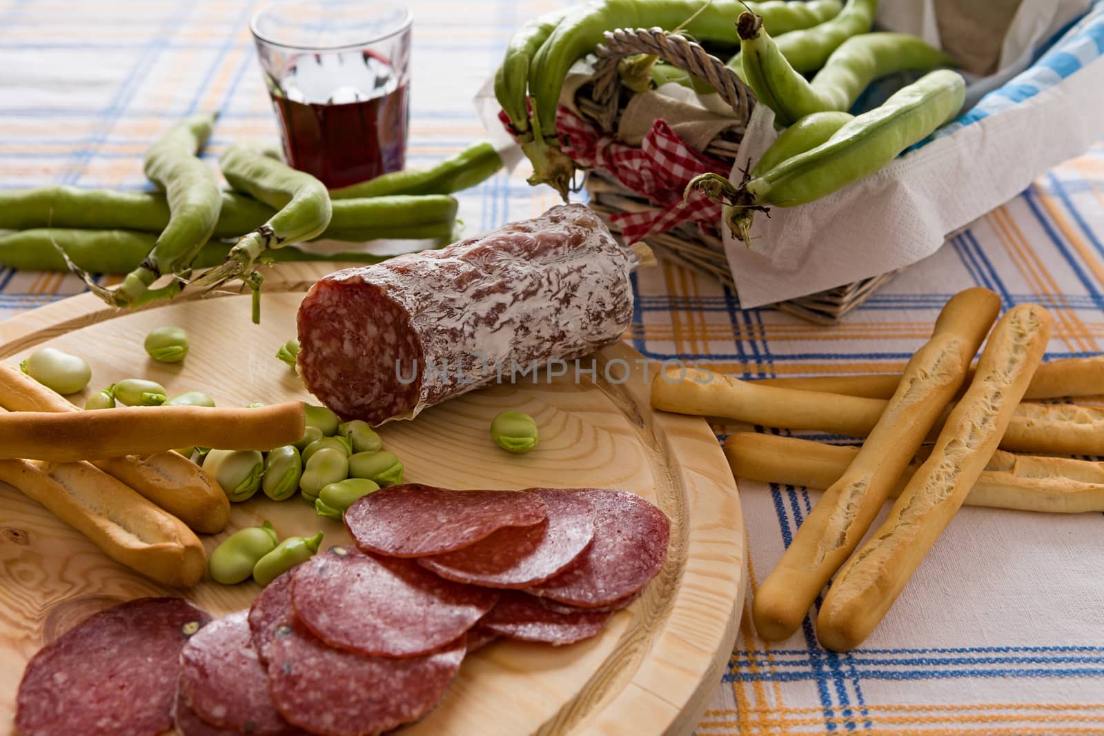 Italian salami broad bean and bread sticks over a chopping board