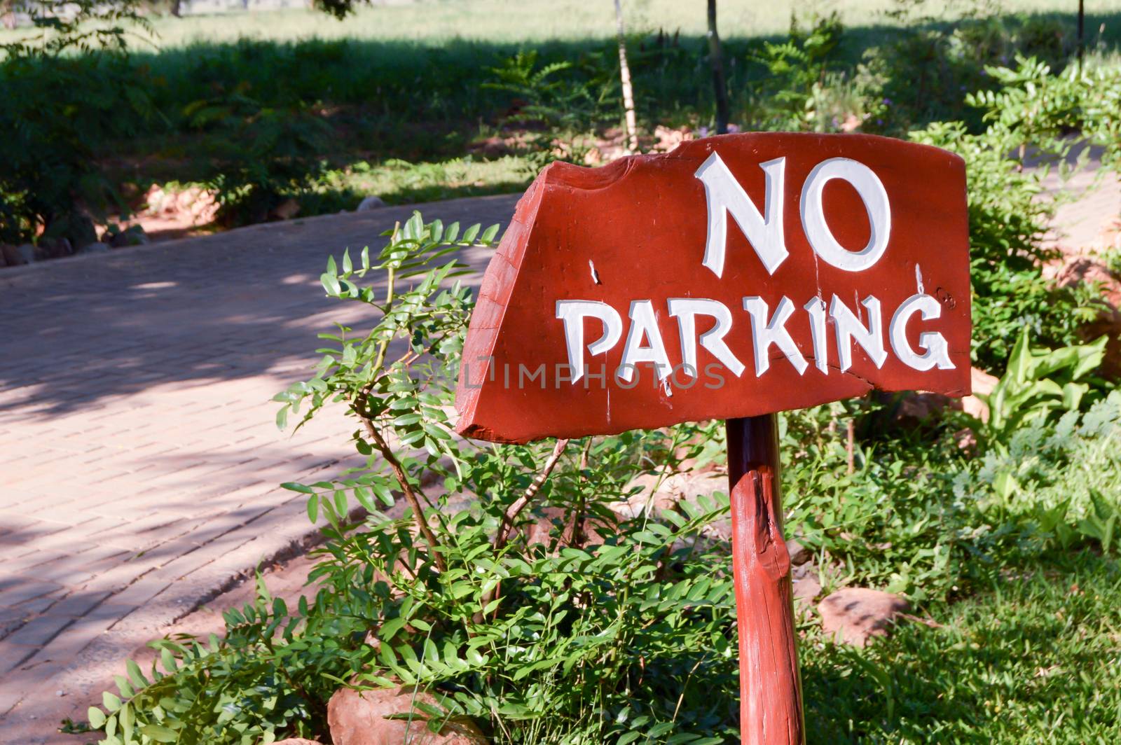 Non-parking sign in white letters on a wooden background at the entrance of a hotel