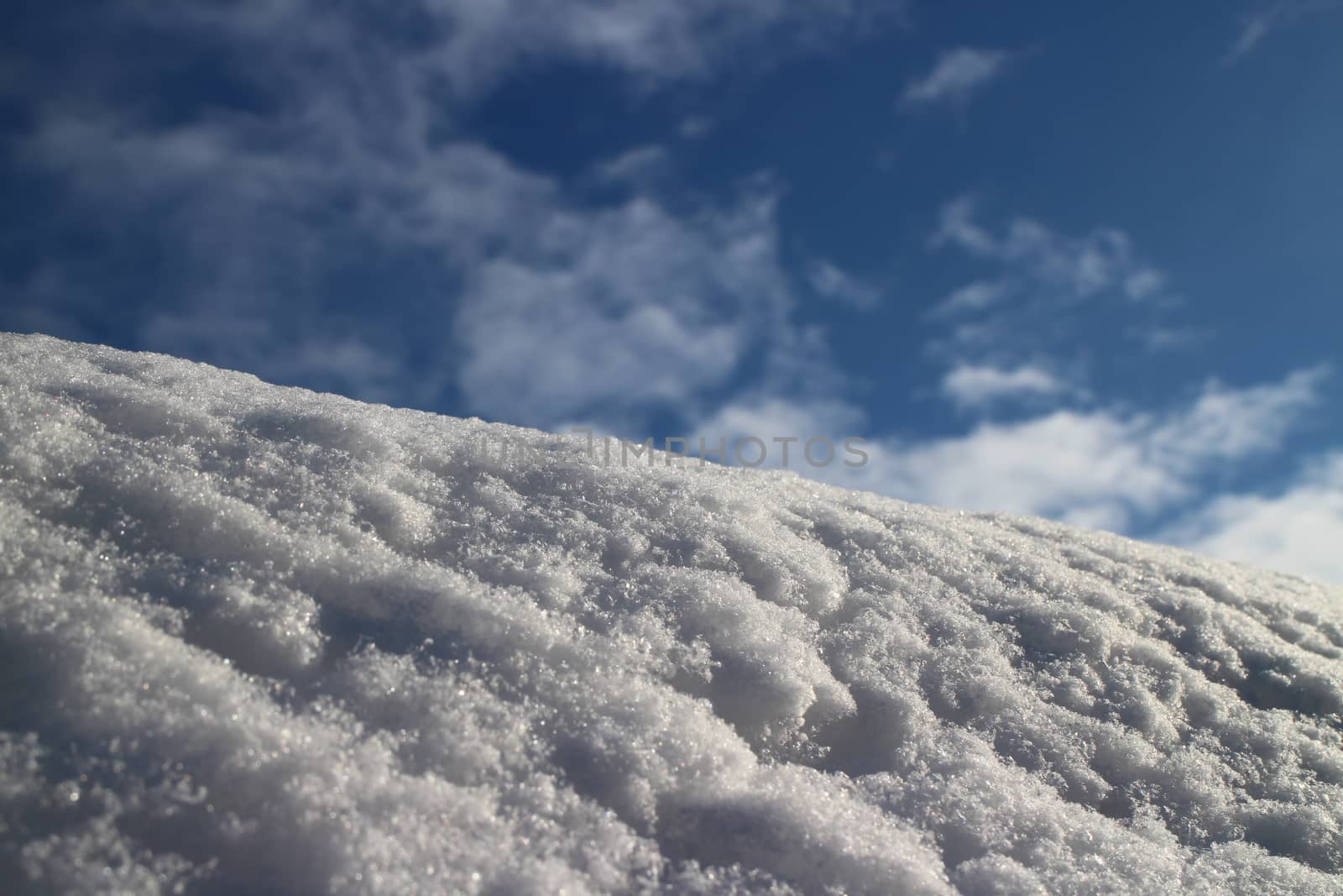 mountain slope covered with white fluffy snow against the blue sky low angle view