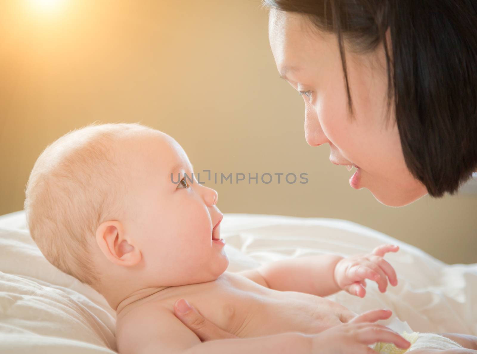 Young Mixed Race Chinese and Caucasian Baby Boy Laying In His Bed with His Mother.