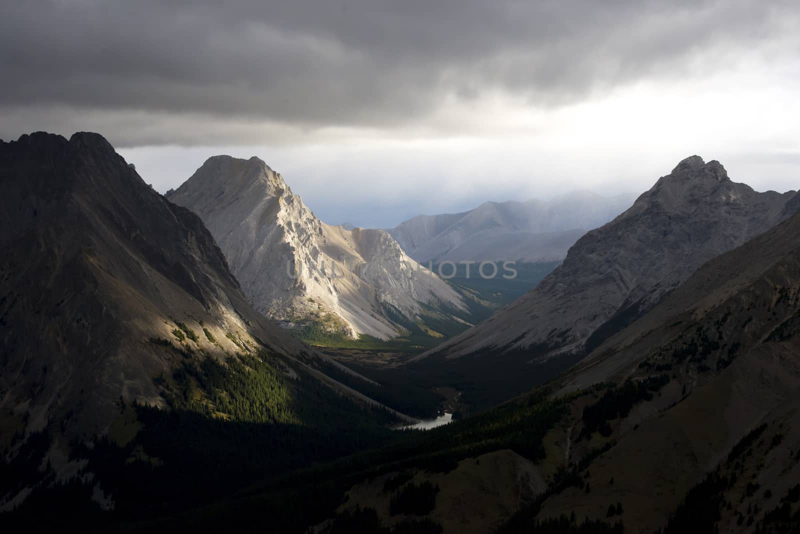 Morning sun light beams illuminate some mountain faces in the fall.