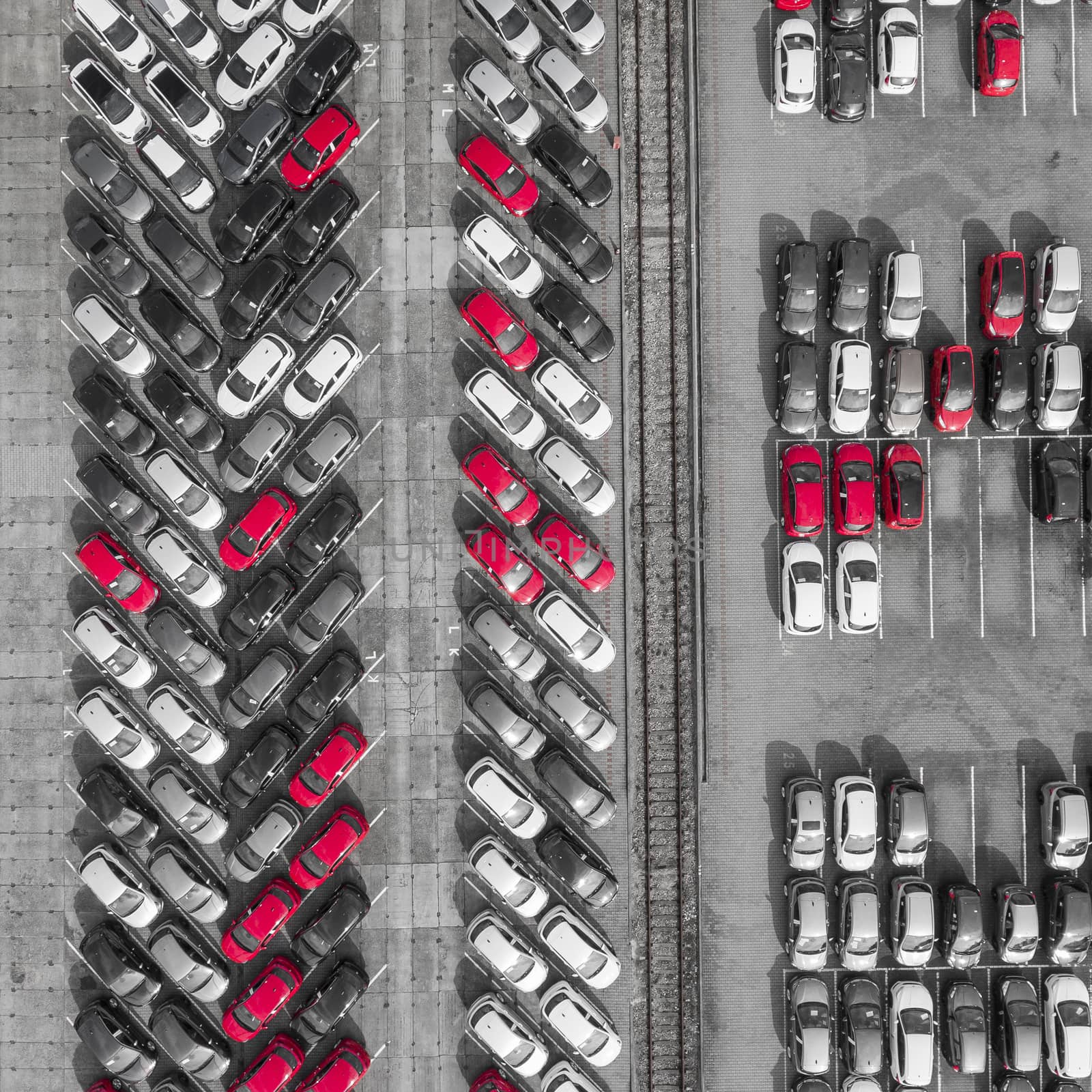 Aerial view lot of vehicles on parking for new car. Black and White selective red colour.