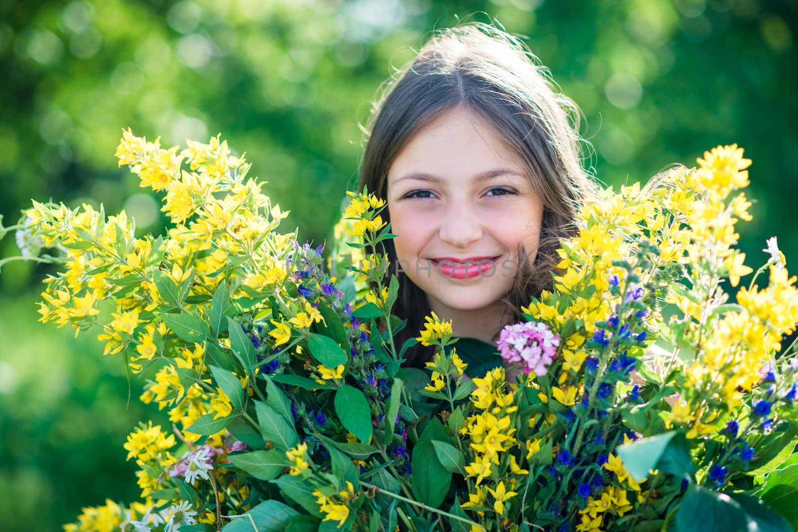 portrait of a girl with flowers in summer sunny day