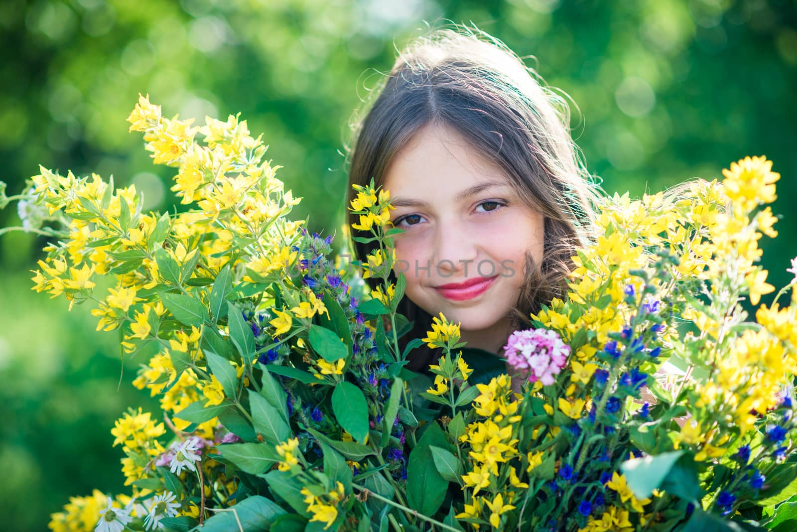 portrait of a girl with flowers in summer sunny day