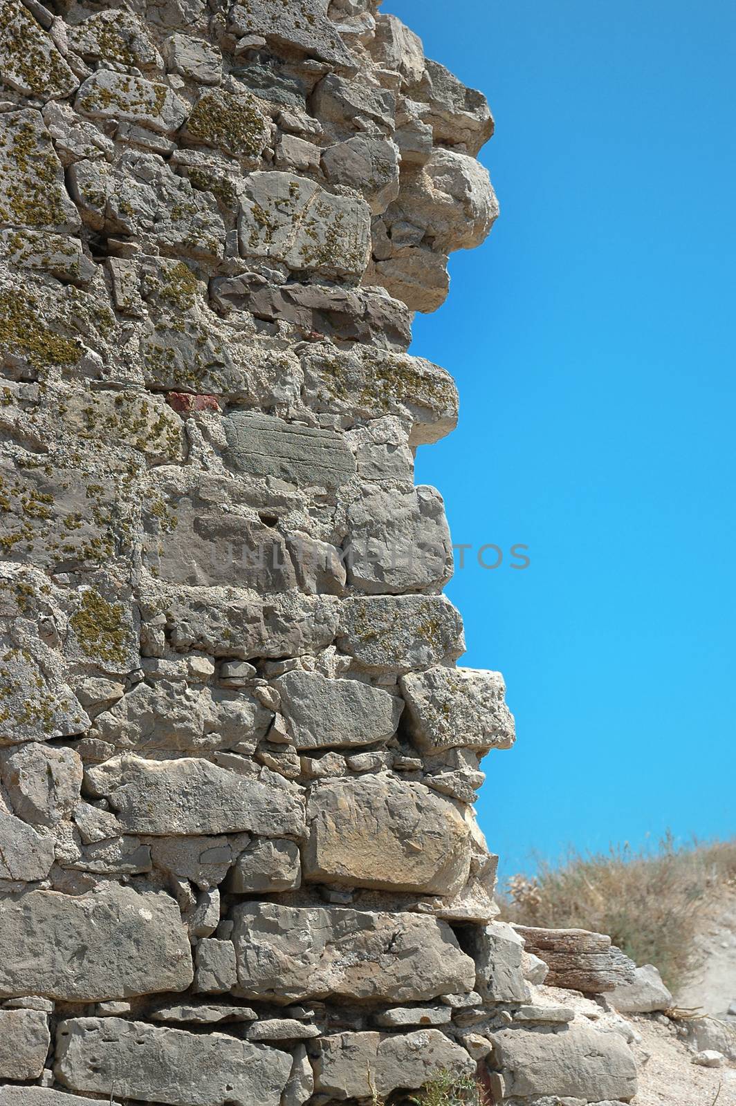 collapsed stone wall in ruins on sky background