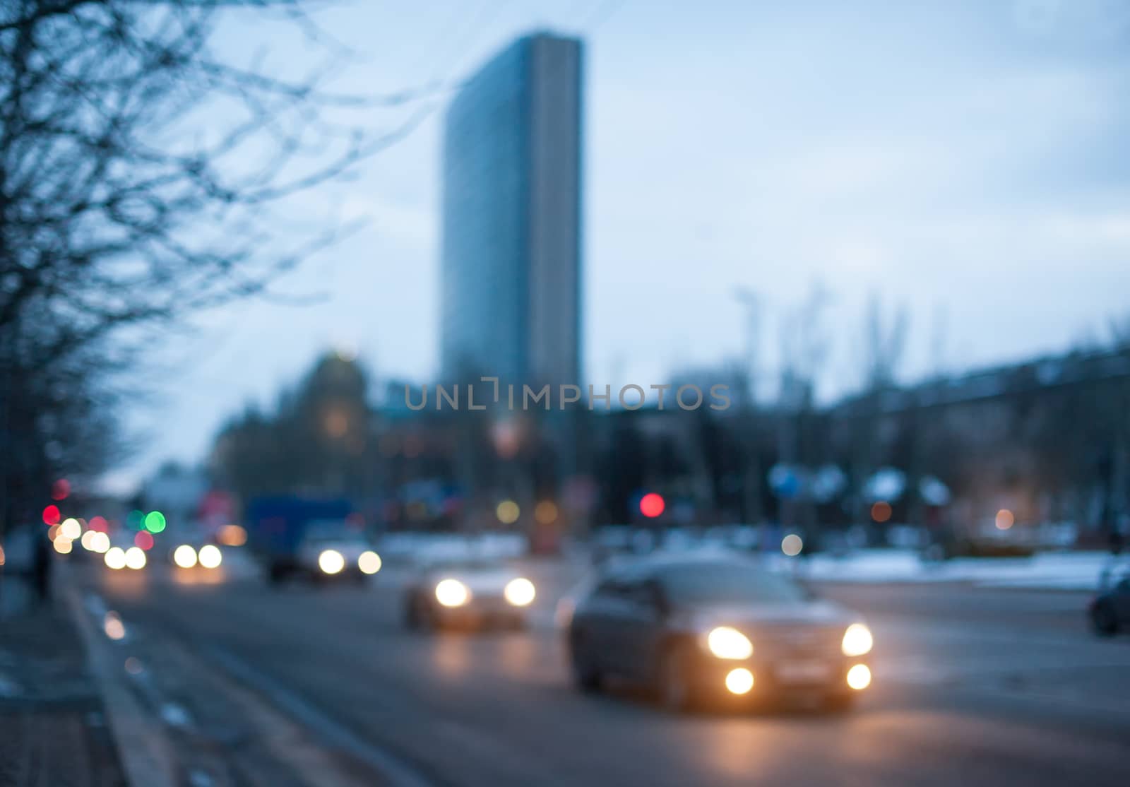 beautiful evening city. cars with headlights on driving on the street by timonko