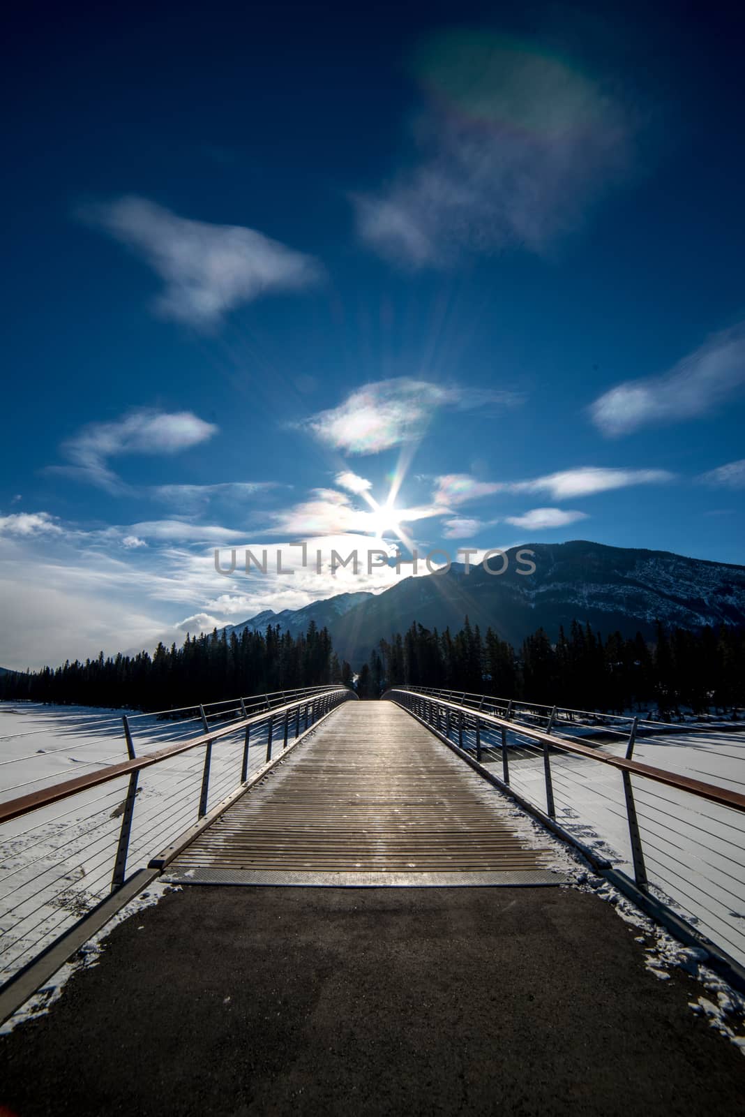 looking across bridge in winter with mountain and blue sky backdrop