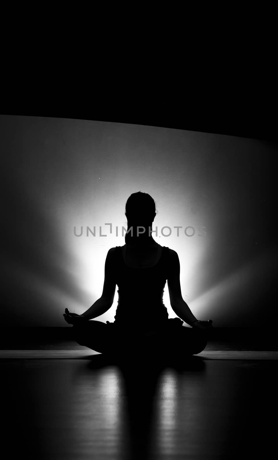 Woman doing yoga lotus pose silhouette black and white in studio