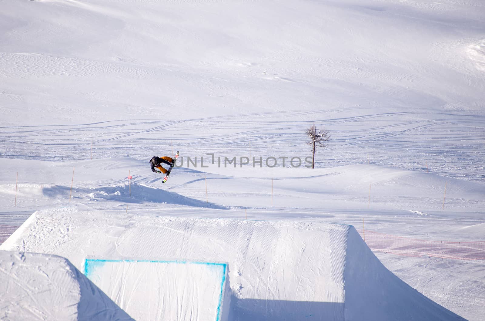 Snowboarder spinning doing a grab in the air off a jump