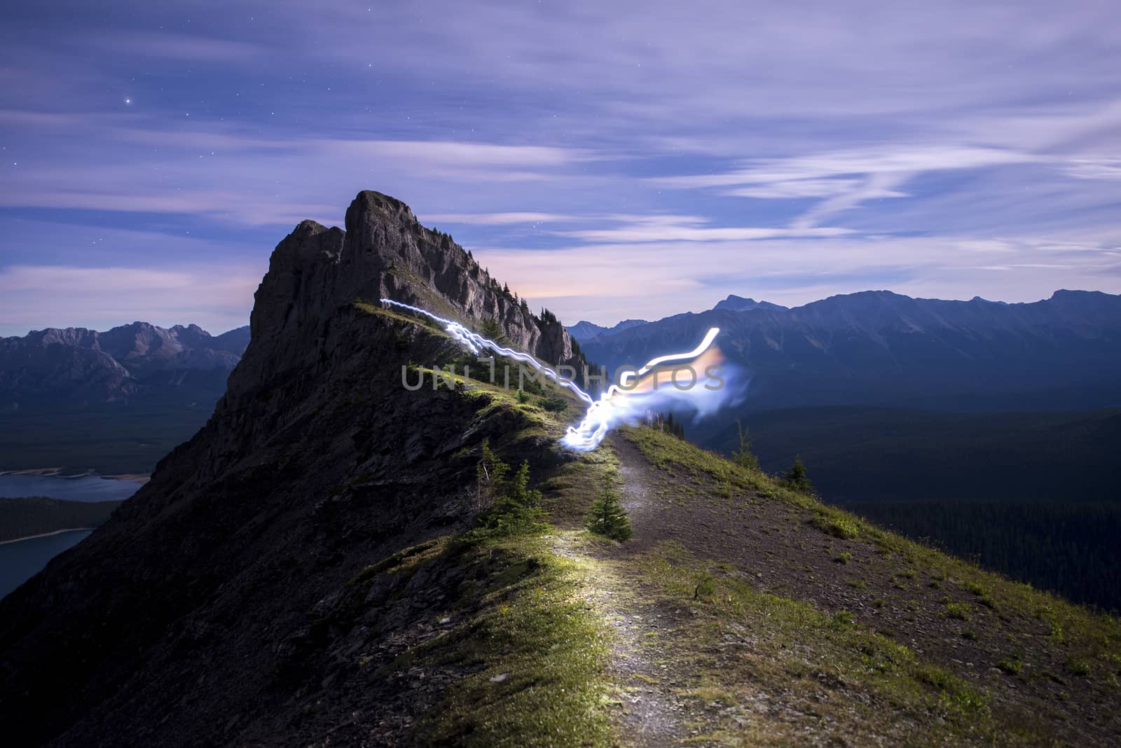 Light trail running along ridge of mountain lit up at night