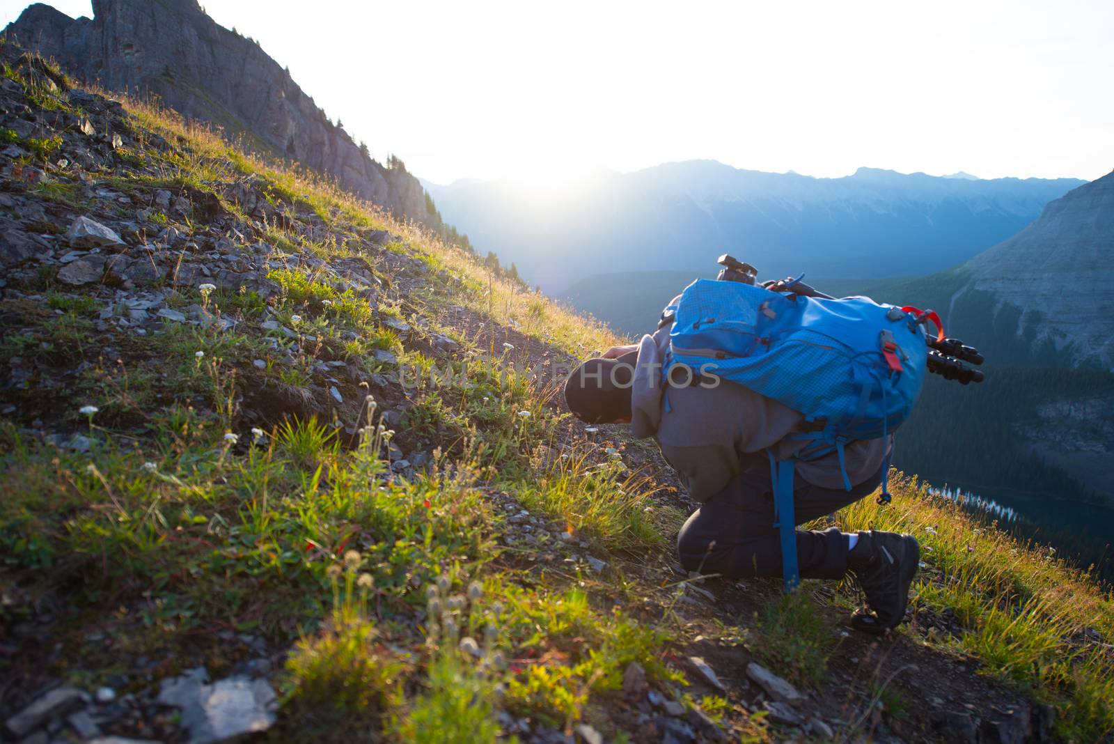 Young man taking picture at sunrise on a mountain