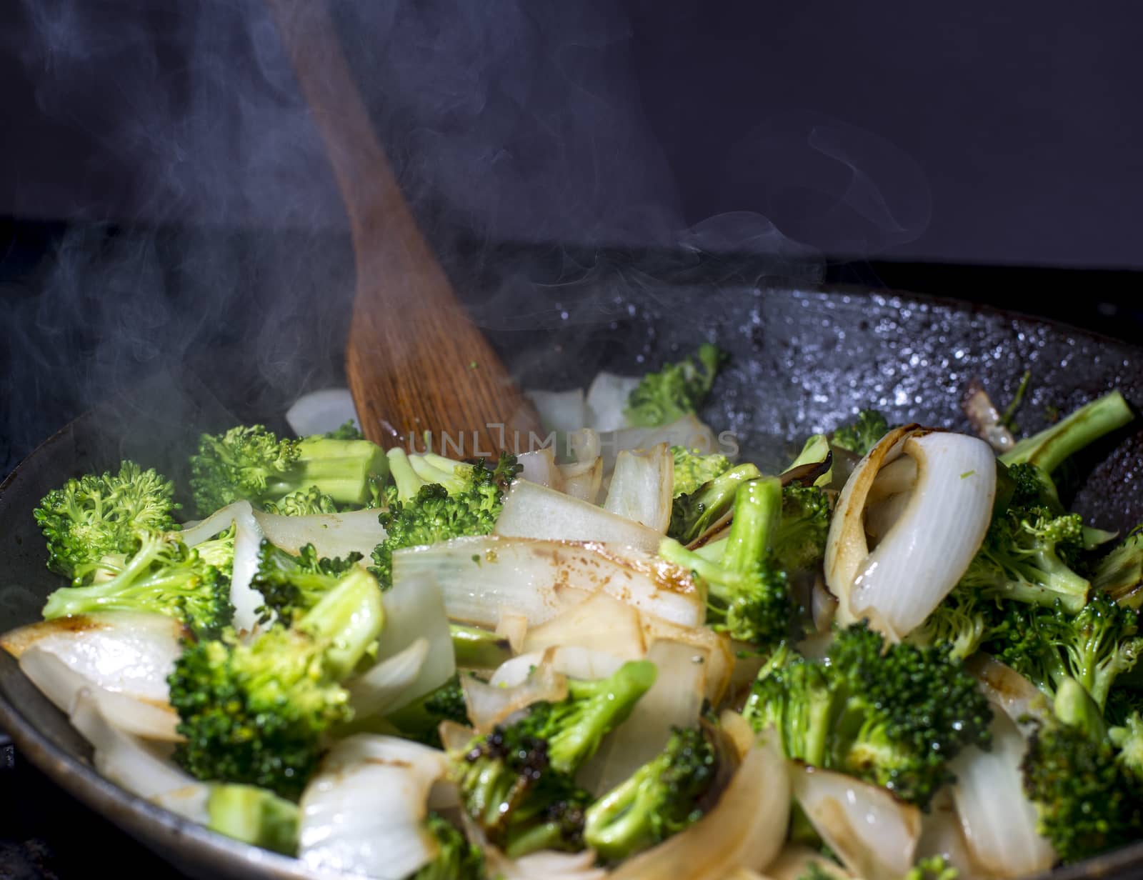 Broccolie and onion stirfry being cooked in pan