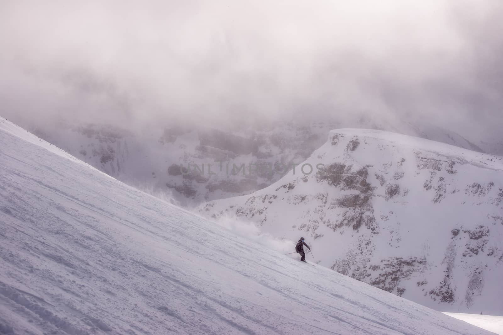 Female skier in mountains skiing fluffy powder
