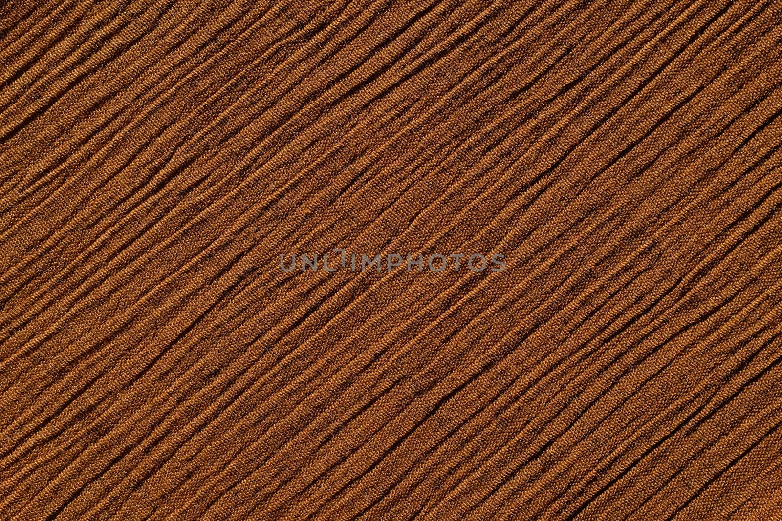 Warm brown crinkled fabric with irregular diagonal lines textile abstract background texture