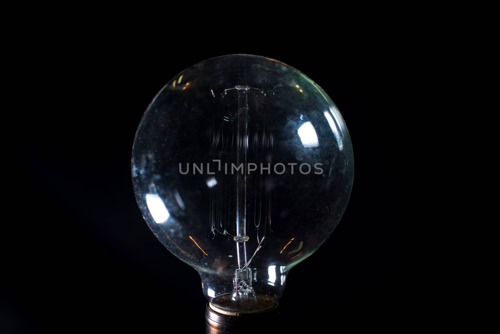 Antique unlit light bulb isolated on black background
