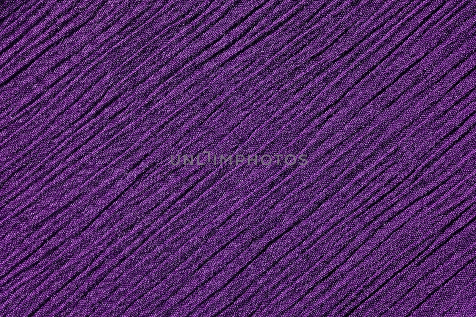Dark purple crinkled fabric with irregular diagonal lines textile abstract background texture
