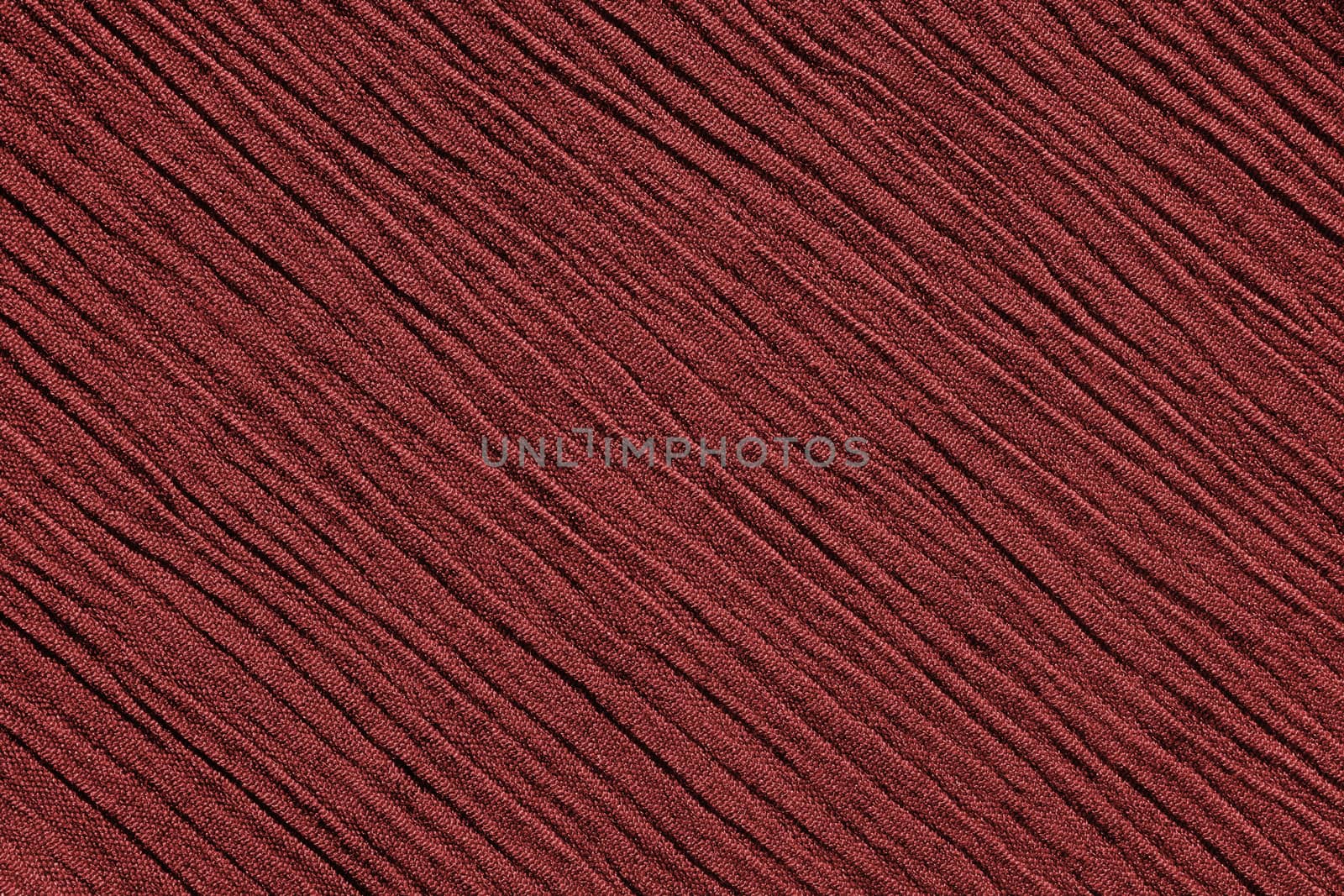Red crinkled fabric with irregular diagonal lines textile abstract background texture