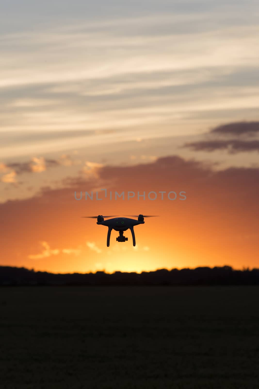 Drone silhouetted against orange sunset by TSLPhoto