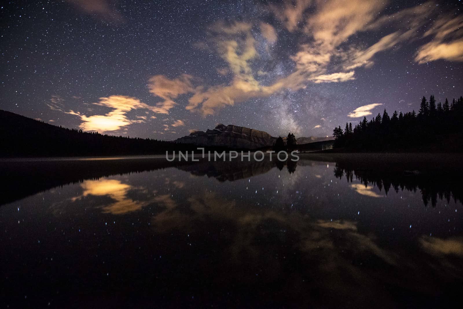 milky way reflecting in lake with mountains