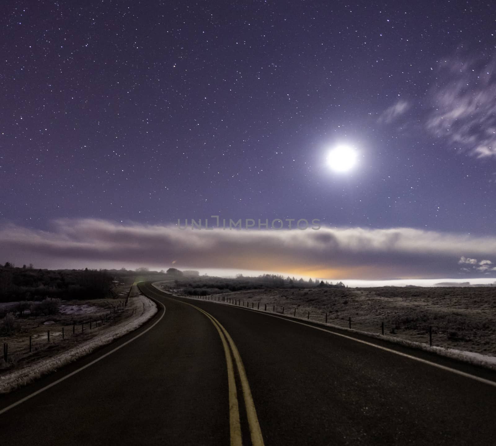 Curved road lit up by the moon by TSLPhoto